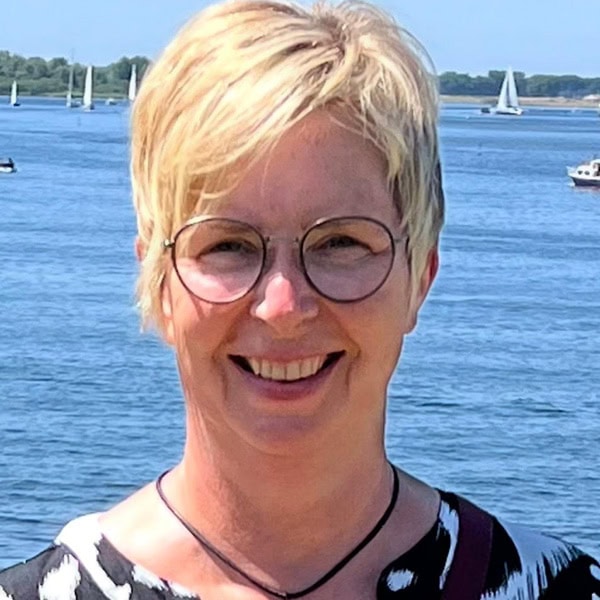 Entspannte Frau mit Kurzhaarfrisur und Brille am Wasser, Duisburg, Kosmetikstudio Balance.